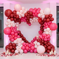 photo backdrop with the Double Heart Frame Arch Backdrop with red, pink and white balloons, pillar candles and loose rose petals