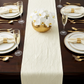 dinner setting with the Embossed Geometric Jacquard Table Runner Ivory, white/gold dinner plates, floral centerpiece and champagne glasses