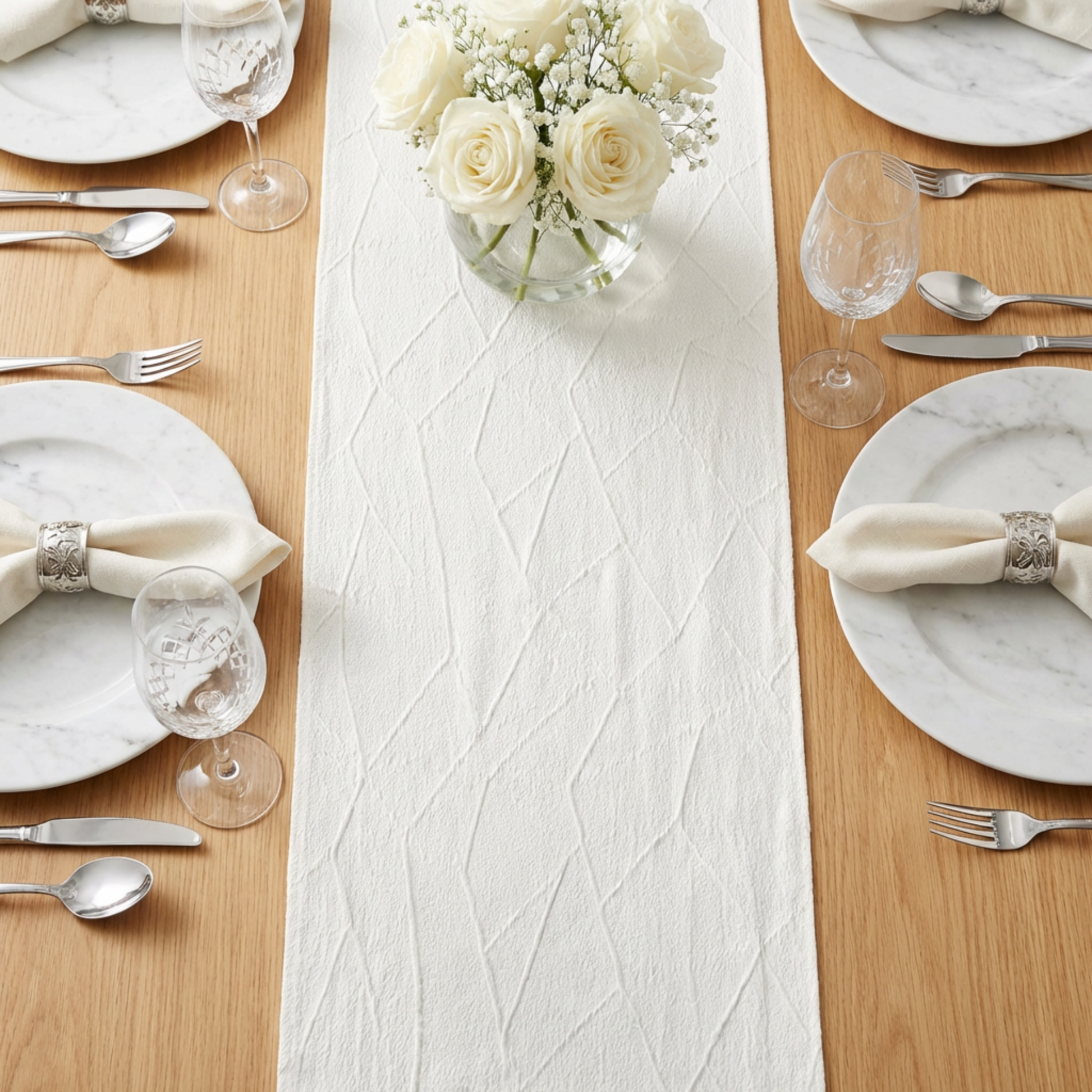 Embossed Geometric Jacquard Table Runner Light Ivory/Off White paired with white roses floral centerpiece, marble charger plates, ivory napkins, and wine goblets