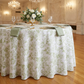 table mockup close up with the French Toile 132" Round Tablecloth Sage Green, napkins sage green, white roses centerpiece and wine goblets