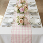 Gingham Checkered Polyester Table Runner Pink & White indoor setting  with mixed floral centerpieces and dinnerware