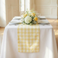 close up of the Gingham Checkered Polyester Table Runner Yellow & White indoor setting  with mixed floral centerpieces and dinnerware