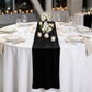Glitter Velvet Table Runner Black  on a white round tablecloth with votive candles, small floral centerpieces, and wine glasses