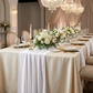 dinner setting with the Glitter Velvet Table Runner White over an ivory tablecloth, floral centerpieces, tapered candles and gold white dinnerware