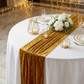 Glitter Velvet Table Runner Gold on a round white tablecloth and gold geometric candle holders