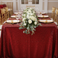 Glitz Sequin 90"x156" Rectangular Tablecloth - Apple Red with flower premade runner | gold charger plate | white napkin | napkin ring | wine goblets
