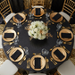 top view showing Glitz Sequins 120" Round Tablecloth - Black with gold charger plate and chiavari chair