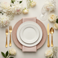 Lace Embossed  Acrylic Plastic Charger Plate Pink Blush table setting with white dinner plates, gold silverware, wine glasses and a white rose floral centerpiece