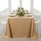 Lamour Satin 90"x132" Rectangular Oblong Tablecloth - Gold Antique with gold charger plate | white napkin | wine goblets | white chiavari chairs