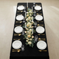 birdseye view of the Luxury Boucle Rectangular Tablecloth Black white dinner plates, gold flatware and wine glasses