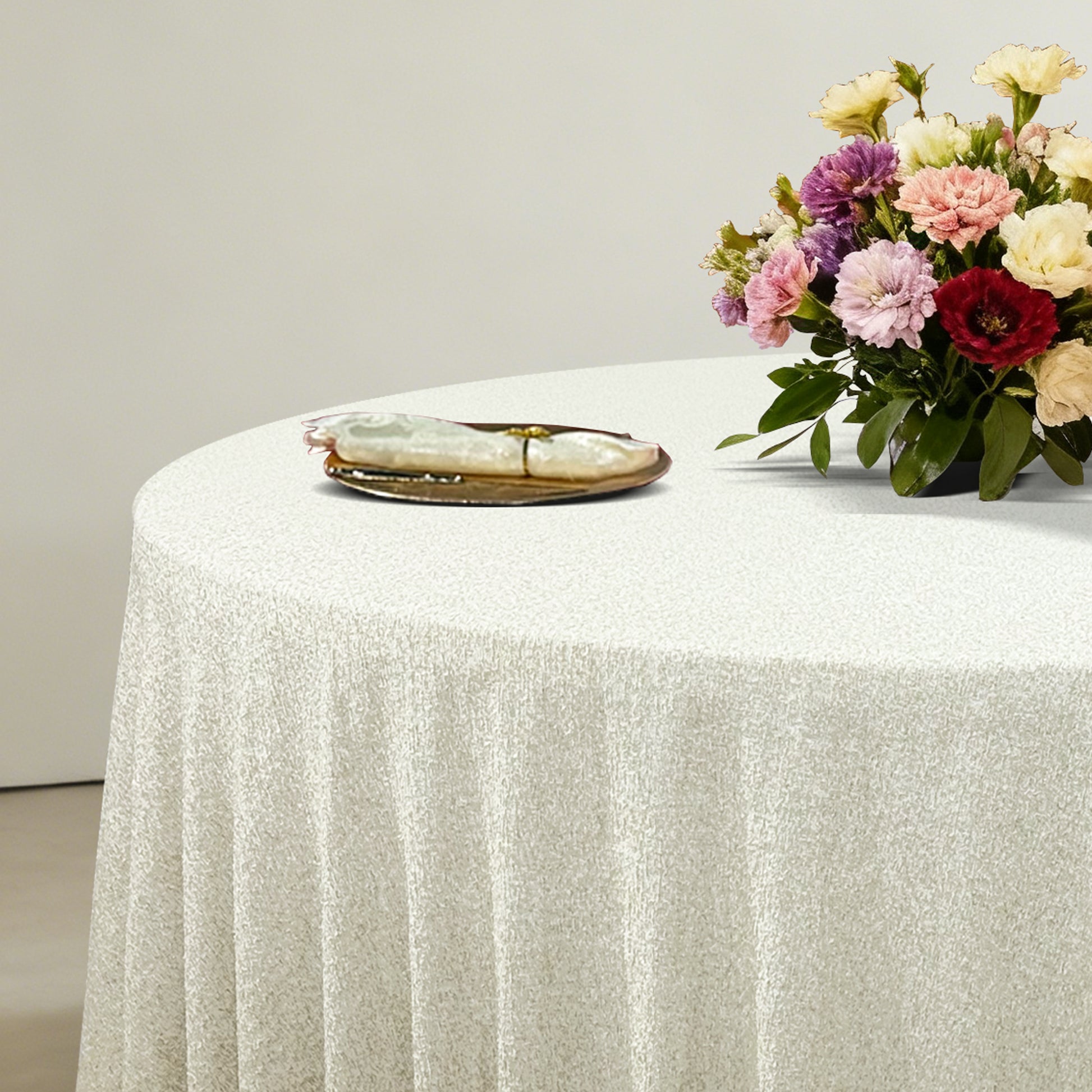 Luxury Boucle Round Tablecloth Beige with floral centerpiece, gold charger plate and ivory napkin with a gold napkin ring