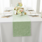 Velvet Table Runner Mint Green on a white tablecloth, white dinner plates and mixed floral centerpiece