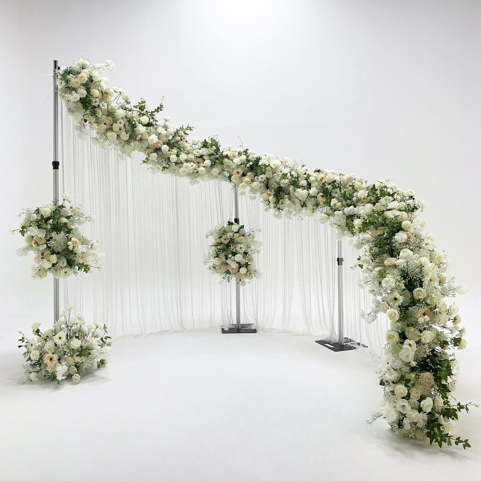 Modern s-curved metal wedding arch backdrop frame  angled view with florals and drapes