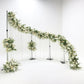 Modern s-curved metal wedding arch backdrop frame decorated with florals and drapes