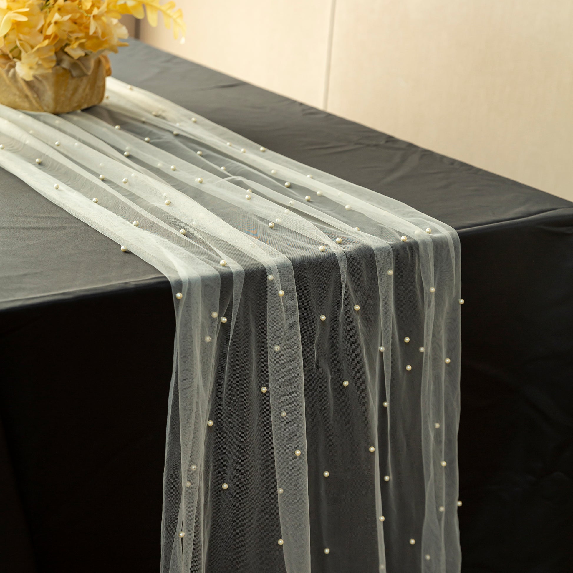 Pearl Tulle Table Runner 30" x 120" Ivory on top a black tablecloth with yellow floral centerpiece 