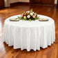 Premium 132" Round White Spun Polyester Tablecloth table setting with floral centerpiece, ivory napkins and gold charger plates