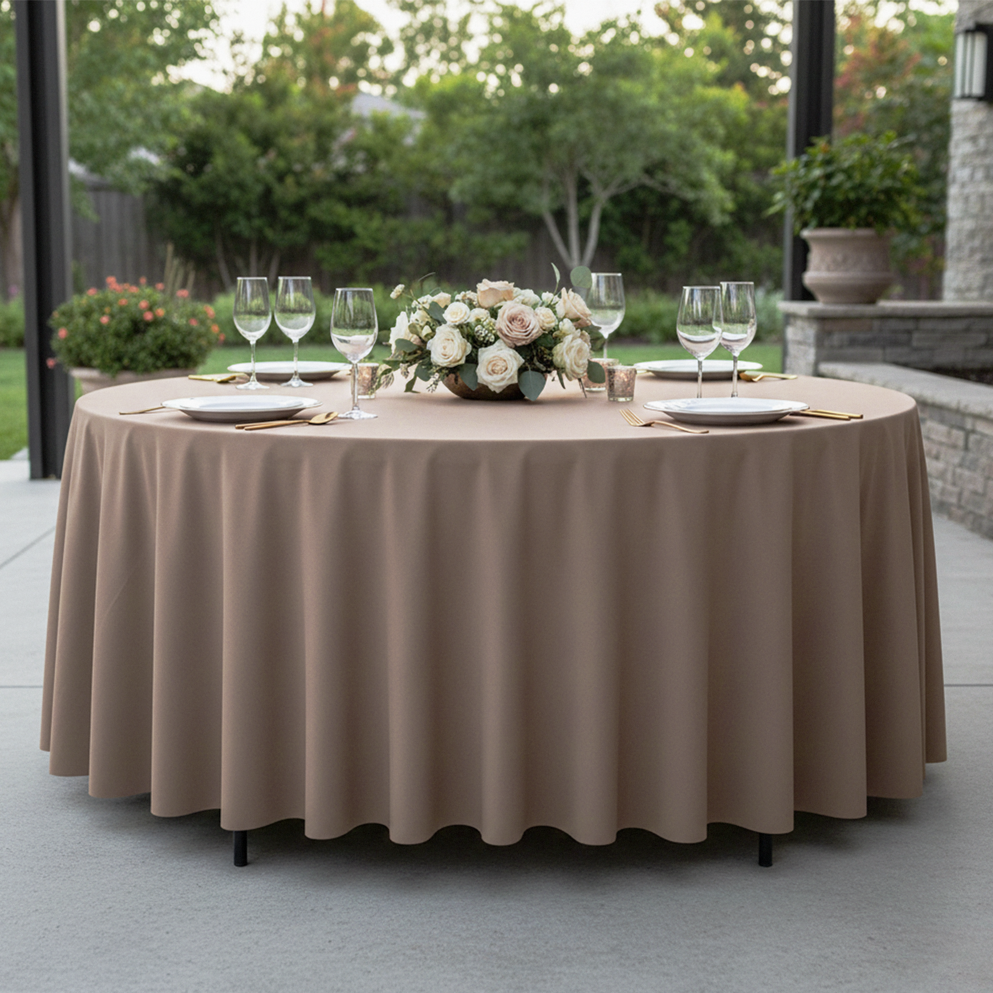 Premium Polyester 90" Round Tablecloth Taupe paired with wine goblets, floral centerpiece, white charger plates and gold silverware