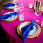 Premium Polyester Napkin 19"x19" - Royal Blue table setting with a gold charger, fuchsia tablecloth, and wine glasses