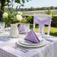 garden brunch setup showing Premium Polyester Napkin 20"x20" - Lavender on top of gingham tablecloth and plain white charger
