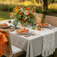 boho garden setup using Premium Polyester Napkin 20"x20" - Orange on top of white tablecloth