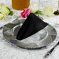 Premium Spun Polyester Napkin 20"x20" Black triangle fold ontop a silver charger plate