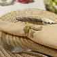 Premium Spun Polyester Napkin 20"x20" - Champagne with a gold ribbon napkin ring on top of a gold charger plate and silverware