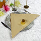 Premium Spun Polyester Napkin 20"x20" Champagnefolded on top a silver charger plate with gold napkin ring