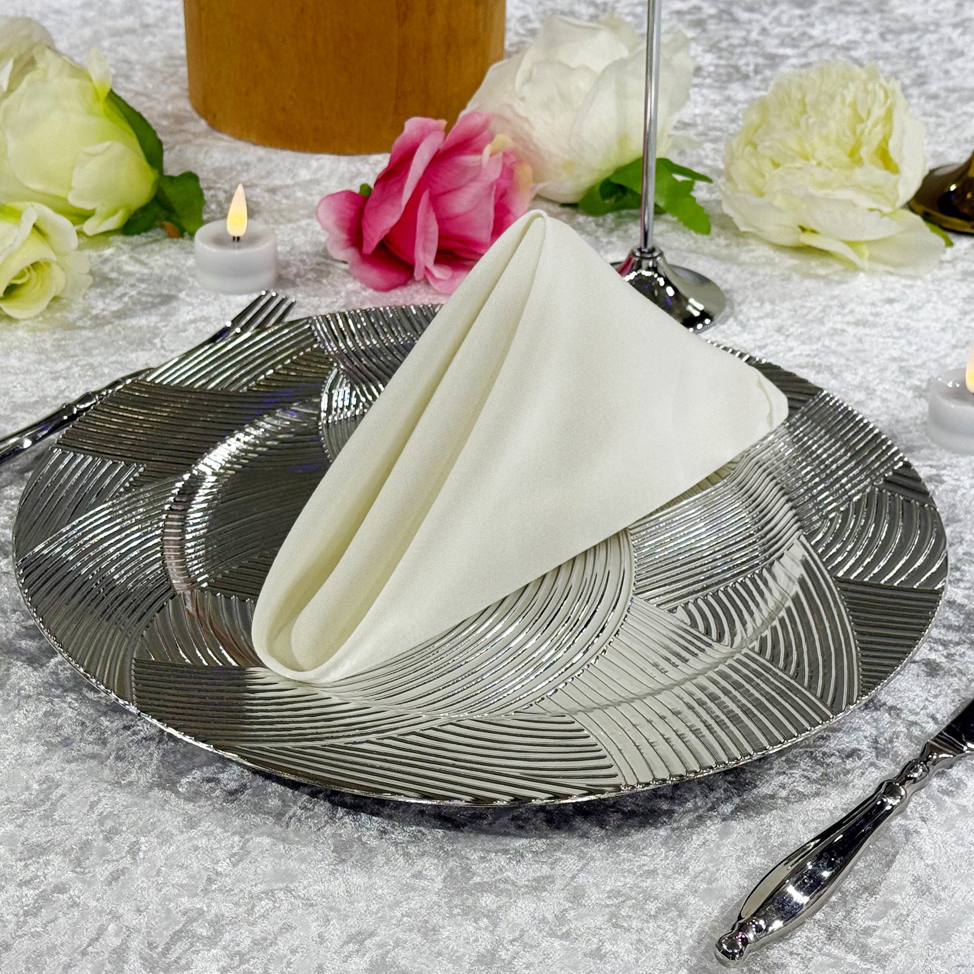 Premium Spun Polyester Napkin 20"x20" Ivory triangle fold ontop a silver charger plate