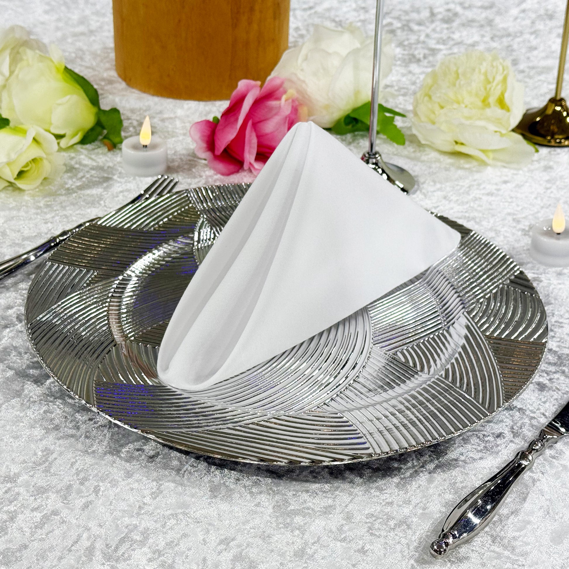 Premium Spun Polyester Napkin 20"x20" White triangle fold ontop a silver charger plate