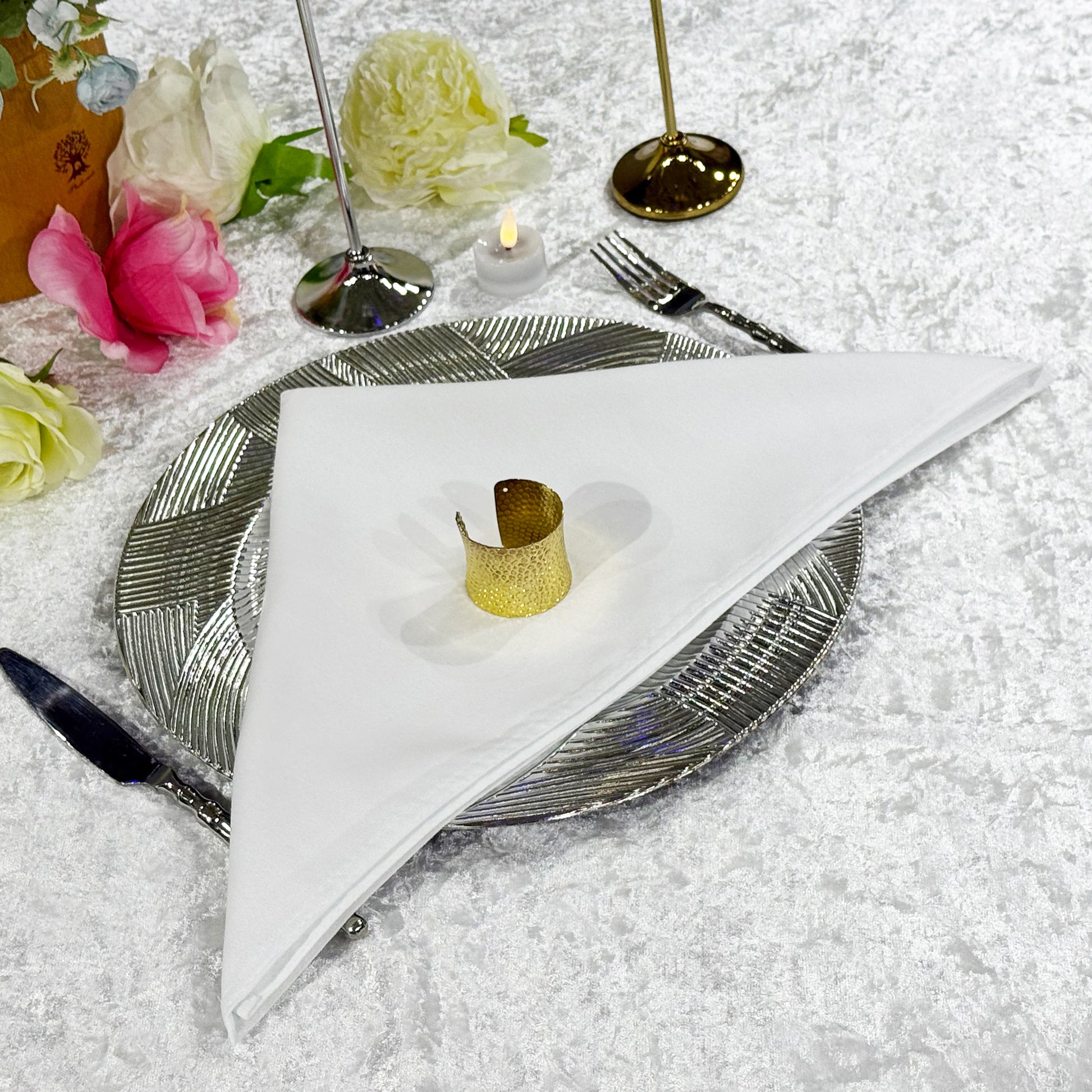 Premium Spun Polyester Napkin 20"x20" White ontop a silver charger palte with gold napkin ring