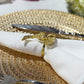 Premium Spun Polyester Napkin 20"x20" White with a gold bow napkin ring and gold charger plate