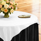 Premium Spun Polyester Square 90"x90" Overlay/Tablecloth White table setting with floral centerpiece, gold charger plate, ivory napkin ontop a black tablecloth 