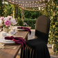 Ruffled Pleated Bottom Spandex Banquet Chair Cover Black outdoor table setting with burgundy napkins, marble dinnerware, and pink florals
