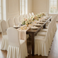 outdoor wedding set up with the Ruffled Pleated Bottom Spandex Banquet Chair Cover Ivory, chiffon table runner, wine goblets and florals