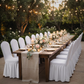 outdoor wedding set up with the Ruffled Pleated Bottom Spandex Banquet Chair Cover White, faux burlap table runner, candles and florals