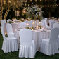 outdoor wedding set up with the Ruffled Pleated Bottom Spandex Banquet Chair Cover White, round tables, white tablecloths, candles and florals