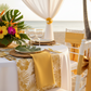 tropical setup showing Satin Napkin 20"x20" - Bright Gold with white tablecloth