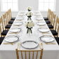 Scalloped Bow Acrylic Charger Plate Black on top of a white tablecloth with water glasses, gold chiavari chairs, and floral centerpieces