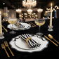 Scalloped Bow Acrylic Charger Plate Black on top a black tablecloth with striped napkins with a gold napkin ring, gold utensils and champagne glasses