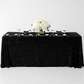 Sequin velvet black rectangular tablecloth with black napkins, white charger plates and wine goblets