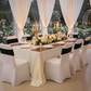 Outdoor wedding reception with ivory and gold accents on the table with white banquet chair covers and Black Spandex Chair Band