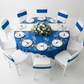 Spandex Chair Band - Royal Blue on top of white chair | white and royal blue tablecloth and overlay | white charger plate | white napkin