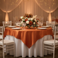 Square 72" Satin Table Overlay - Burnt Orange with gold trimmed charger plate | white dinner plate | wine goblets | gold chiavari chair | white tablecloth