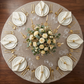 bird's eye view of the Velvet 132" Round Tablecloth Taupe on a 72 inch round table with a floral centerpiece ivory napkins, and tapered candles