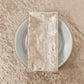 Velvet 20"x20" Linen Napkin Taupe  on a white charger plate paired with a Velvet Taupe tablecloth