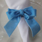 Velvet Bow Tie Napkin Ring Baby Blue  on a white napkin close up