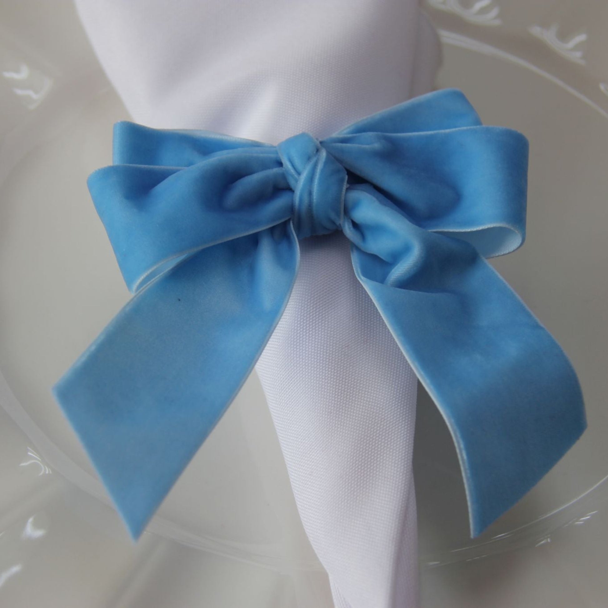 Velvet Bow Tie Napkin Ring Baby Blue  on a white napkin close up