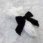 Velvet Bow-Tie Napkin Ring Black on a white polyester napkin