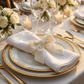 Velvet Bow Tie Napkin Ring Ivory with a white napkin on top of white gold trimmer dinner plates