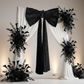 Velvet Giant Fabric Bow for Backdrop Black paired with white sheer drapes and mixed black florals